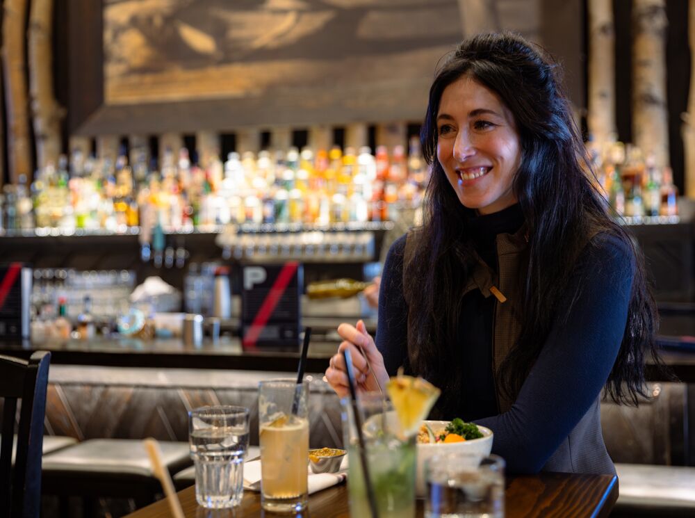 A woman has lunch at PARK Distillery in Banff National Park.